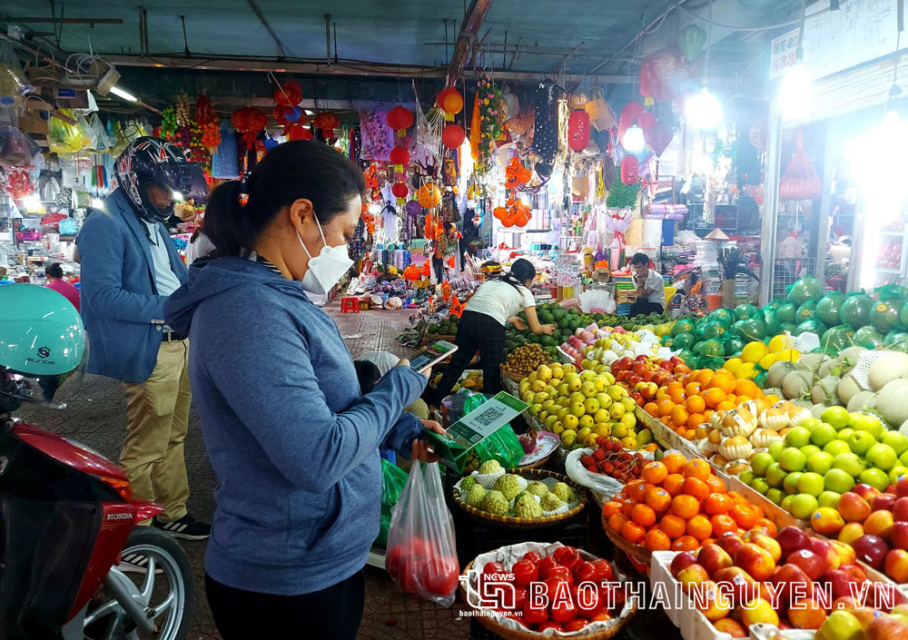 Khách hàng quét mã QR thanh toán khi mua hàng tại chợ Thái, TP. Thái Nguyên.
